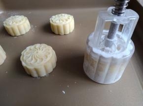 50克的月饼模在装有玉米淀粉的碗里压一下，抖去多余的淀粉，将月饼圆坯放入模具里，轻压模具，推出月饼坯