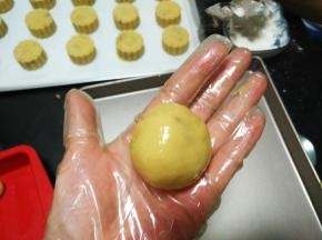 用手的虎口位置，把饼皮的四周向上推，边推边收口，包好，滚圆