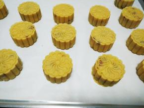 摆入烤盘，在月饼表面喷水