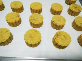 摆入烤盘，在月饼表面喷水