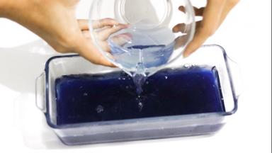 把第一层从冰箱取出，轻轻将已冷却成室温的浅色蝶豆花水倒入模具中，放冰箱冷藏约1小时