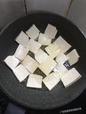 锅烧热倒入适量的油，放入豆腐中小火慢慢煎制。