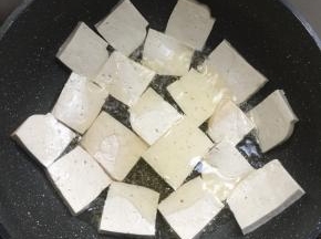 锅烧热倒入适量的油，放入豆腐中小火慢慢煎制。