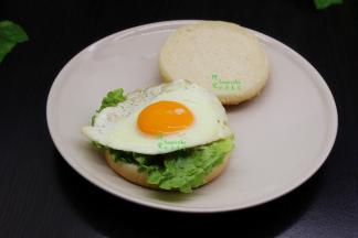 然后把煎好的鸡蛋放上，再盖上上汉堡胚，完美的西式风味早餐就好了