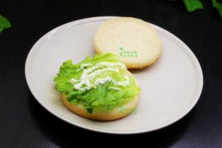 汉堡里挤上沙拉，然后放生菜、再挤一层沙拉；这个时候可以在旁边教孩子做，锻炼他们自己的动手能力。