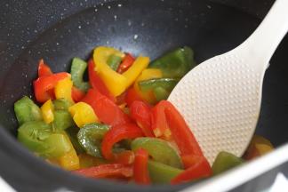 用炒菜机配置的锅铲，铲出烹饪好的彩椒