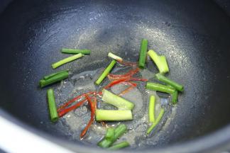 炒好的丝瓜取出，装盘，锅内放入油、葱段、辣椒丝和调味料