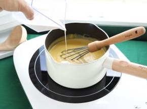 将南瓜浓汁倒入奶锅内，再倒入淡奶油，电磁炉中小火加热