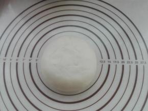 用水油皮面团将油酥面团包裹好，捏紧收口，盖好保鲜膜醒发5分钟。