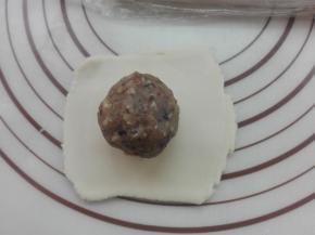 取一个切好的剂子，将其擀薄，放入馅料（馅料在后面备注有讲）