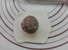 取一个切好的剂子，将其擀薄，放入馅料（馅料在后面备注有讲）