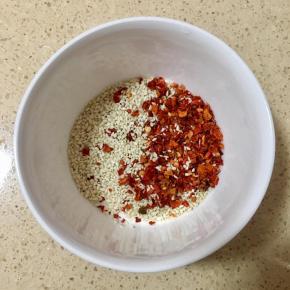 将白芝麻和辣椒粉一起倒入碗里。