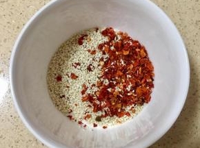 将白芝麻和辣椒粉一起倒入碗里。