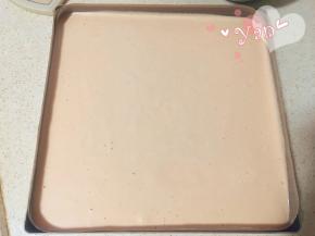 把蛋糕面糊倒入烤盘中，用刮刀抹平。