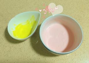 挖出两勺酸奶慕斯糊，分别加入一点红丝绒液和黄色色素，拌匀。