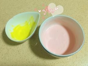 挖出两勺酸奶慕斯糊，分别加入一点红丝绒液和黄色色素，拌匀。