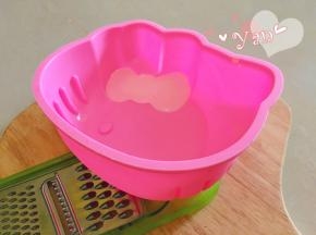 准备好硅胶模具，由于蝴蝶结部分是斜的，要先用东西垫高，使蝴蝶结尽量水平状态。
将粉色慕斯糊挤到蝴蝶结的位置，填满之后放入冰箱，冷藏至凝固。