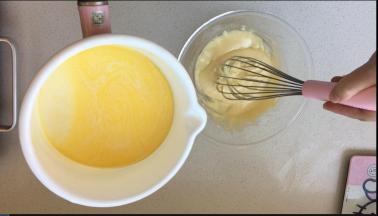 当奶锅中的牛奶冒出小泡，离火。将一半的牛奶，缓缓的倒入到蛋黄糊中。