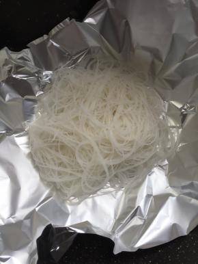 麦饭石不粘锅烧热倒入少许的油，铺上锡纸。把泡好的粉丝放在锡纸上。
