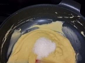 接着倒入白糖，继续小火慢炒。