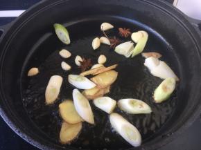 将锅烧热，放入少许的底油，放入葱姜蒜八角，炒出香味。