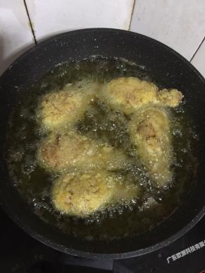 锅烧热倒入适量的油，烧至七成热（用无水的竹筷子插在油锅里，冒泡泡就可以了。）放入裹好面包糠的鸡腿，中小火慢慢的炸。