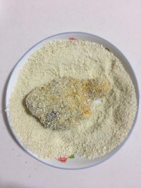 裹上面包糠，要充分裹满，不留缝隙。用手按压一下，把多余的面包糠抖掉。