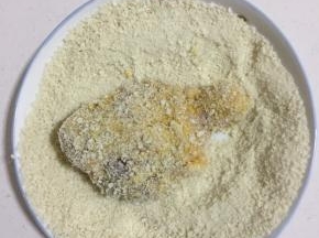 裹上面包糠，要充分裹满，不留缝隙。用手按压一下，把多余的面包糠抖掉。