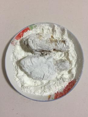 腌制好的鸡腿放在玉米淀粉中均匀的裹满玉米淀粉。