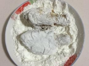 腌制好的鸡腿放在玉米淀粉中均匀的裹满玉米淀粉。