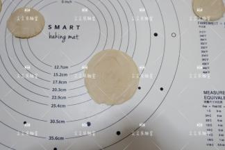 取一个小剂子压扁并且将边缘擀薄一点，剩余的盖好保鲜膜备用。