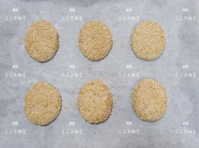 将白芝麻倒入平盘中，将包好的酥饼表面均匀的粘上白芝麻，全部做好放入烤盘。