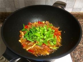 放入青椒和韭菜翻炒20秒。