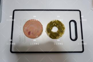 先盖上一片切片火腿，堵住贝果的肚脐眼哈