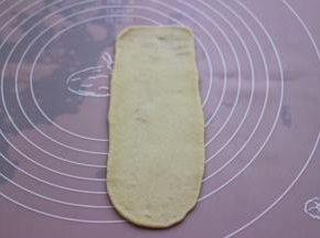 取一块松弛好的面团，用擀面杖擀成长舌状。