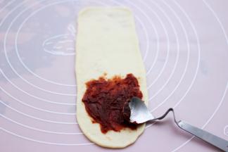 把豆沙馅放上去。(也可以把豆沙馅压扁，和面团一起擀成长舌状，根据个人喜欢来。)