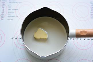 奶锅里放入奶油和黄油，用小火加热至沸腾，