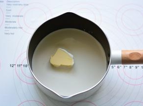 奶锅里放入奶油和黄油，用小火加热至沸腾，