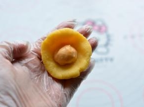 取奶黄馅捏成面皮状，包入冷冻好的流心馅，流心馅需要冷冻到足够硬，包的时候最好在冰箱里面包，防止融化，如果拿出来包，一个一个的拿，包完一个再拿另一个