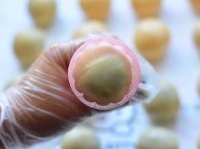 把做好的月饼面团，放入月饼模具中，稍微压一下，月饼模具转移到烤盘上，用力按压月饼模具，然后轻轻提起月饼模具，让月饼成型，放在烤盘上，依次把所有的月饼做好，每做一个，都要沾一下面粉，用来防粘