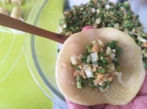 冰箱取出冷藏的核香馅，取8克馅放在面团中间，之后用手指压一下馅，包裹上内馅，捏紧收口