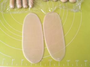 全部包裹好后，取两份先前包裹好的面团，用擀面杖擀成长条，因为面团特别小，一个一个擀很费时间，时间太长面团容易干，所以我们就两个两个的一起擀 