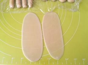 全部包裹好后，取两份先前包裹好的面团，用擀面杖擀成长条，因为面团特别小，一个一个擀很费时间，时间太长面团容易干，所以我们就两个两个的一起擀 