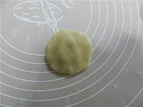 取一个饼皮，饼皮放手掌上压扁，月饼皮用旋转的手势捏薄一点（我用50克模具）