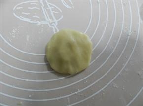 取一个饼皮，饼皮放手掌上压扁，月饼皮用旋转的手势捏薄一点（我用50克模具）