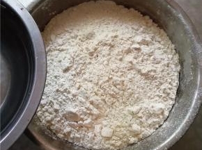 面粉和酵母放入容器内，慢慢加入清水。