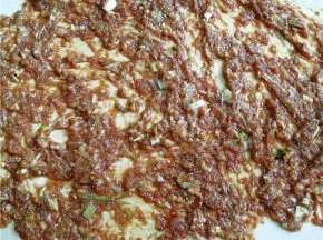 将面团擀成片，将肉馅涂抹于面片上。