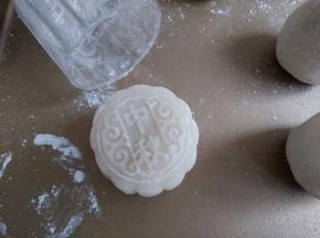 50克月饼模在熟糯米粉上盖一下，再把月饼模在手上磕一磕，磕去多余的粉，再把包好的面团放入模具里，向下压出形状