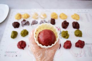 表面再撒上适量的手粉，放入月饼模具中，按压平整
