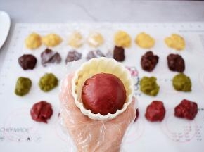 表面再撒上适量的手粉，放入月饼模具中，按压平整
